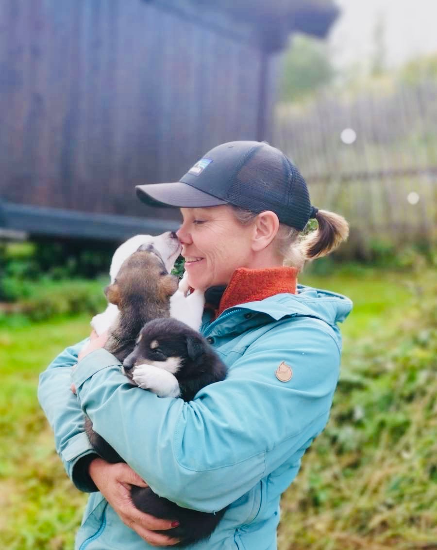 Lene Nyhus holder tre huskyvalper ute ved hundegården